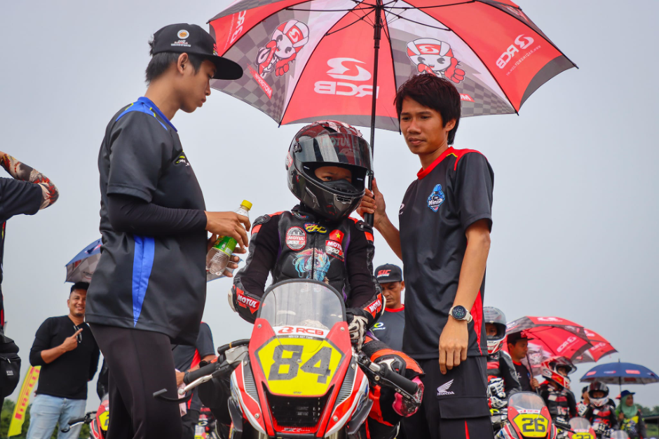 Anh Tuấn (cầm ô) và con trai trước giờ thi đấu tại một giải đua quốc tế. Ảnh: nhân vật cung cấp